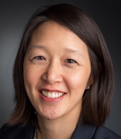 Portrait of a smiling female researcher with shoulder-length dark hair.